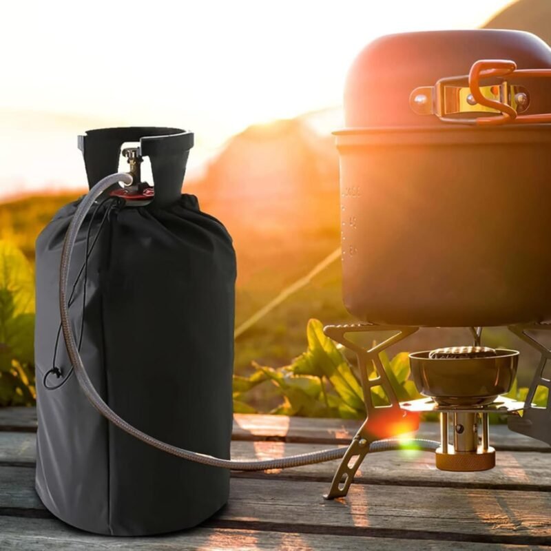 Housse noire pour bouteille de gaz sur une bouteille en extérieur à côté d’un réchaud de camping