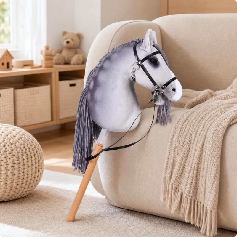 Cheval bâton gris pommelé avec bride noire appuyé sur un canapé dans un salon