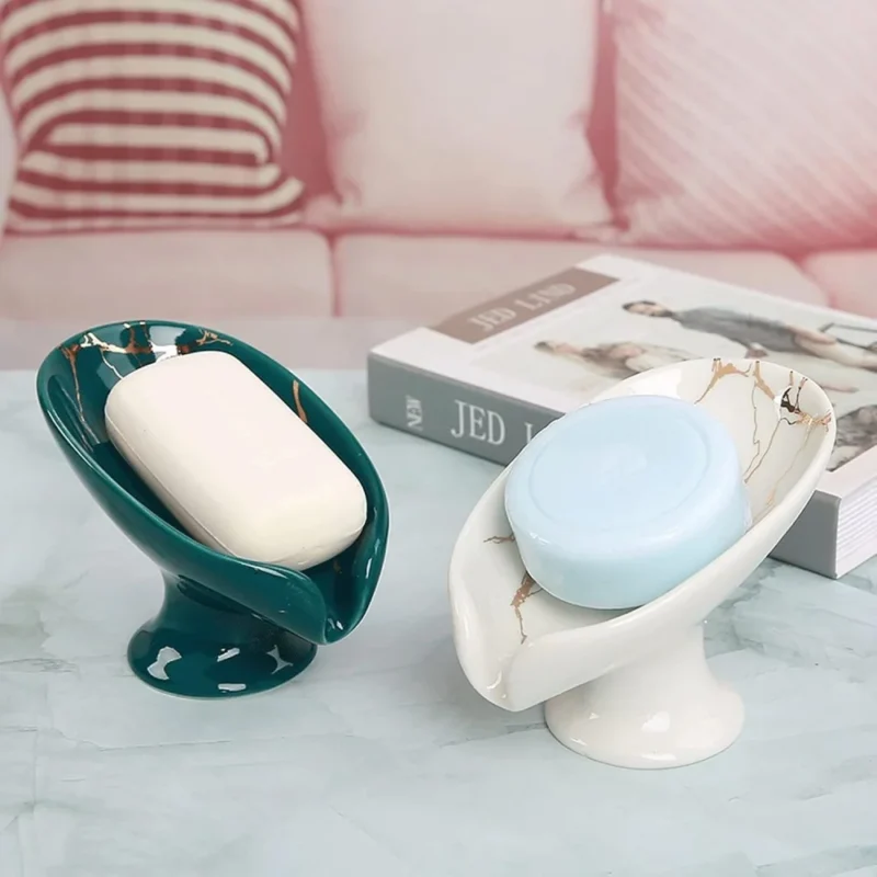 Porte-savons autodrainants en céramique verts et blancs sur une table