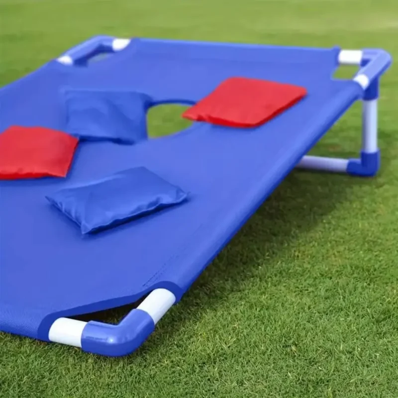 Planche de lancer de sacs bleue avec sacs lestés sur une pelouse