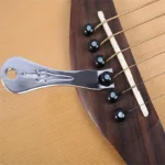 Arrache-chevilles soulevant une cheville de chevalet sur une guitare acoustique