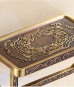 Gros plan sur la tablette gravée en laiton vieilli du porte-papier toilette
