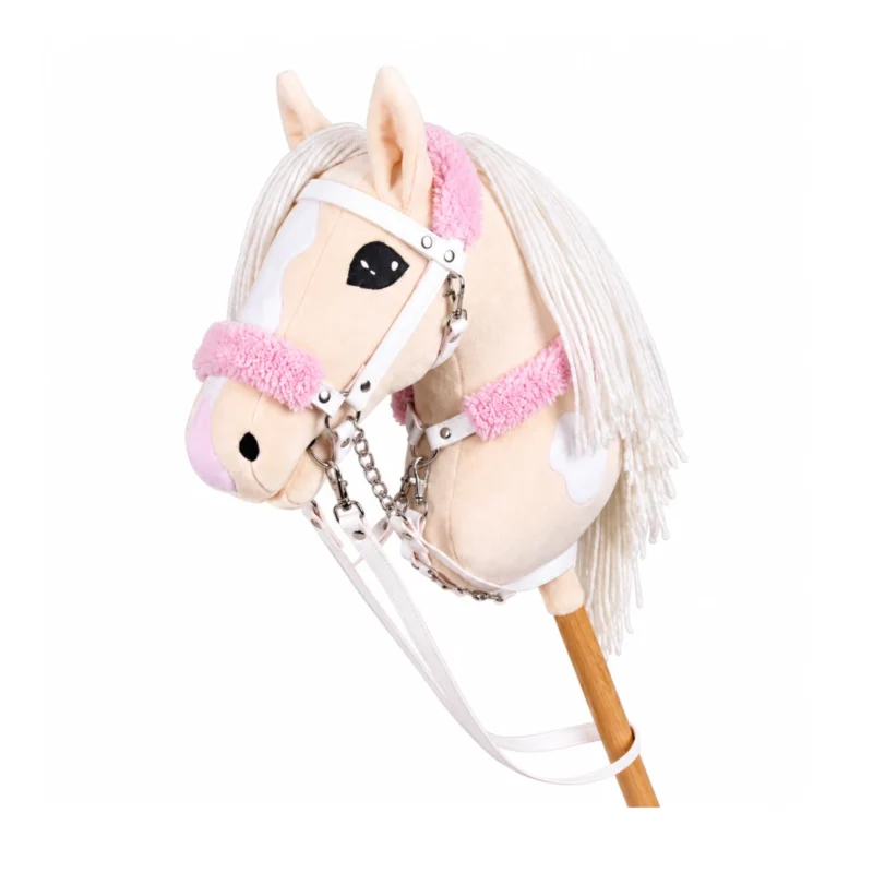 Cheval bâton pie crème avec crinière blanche et bride blanche avec mouton rose